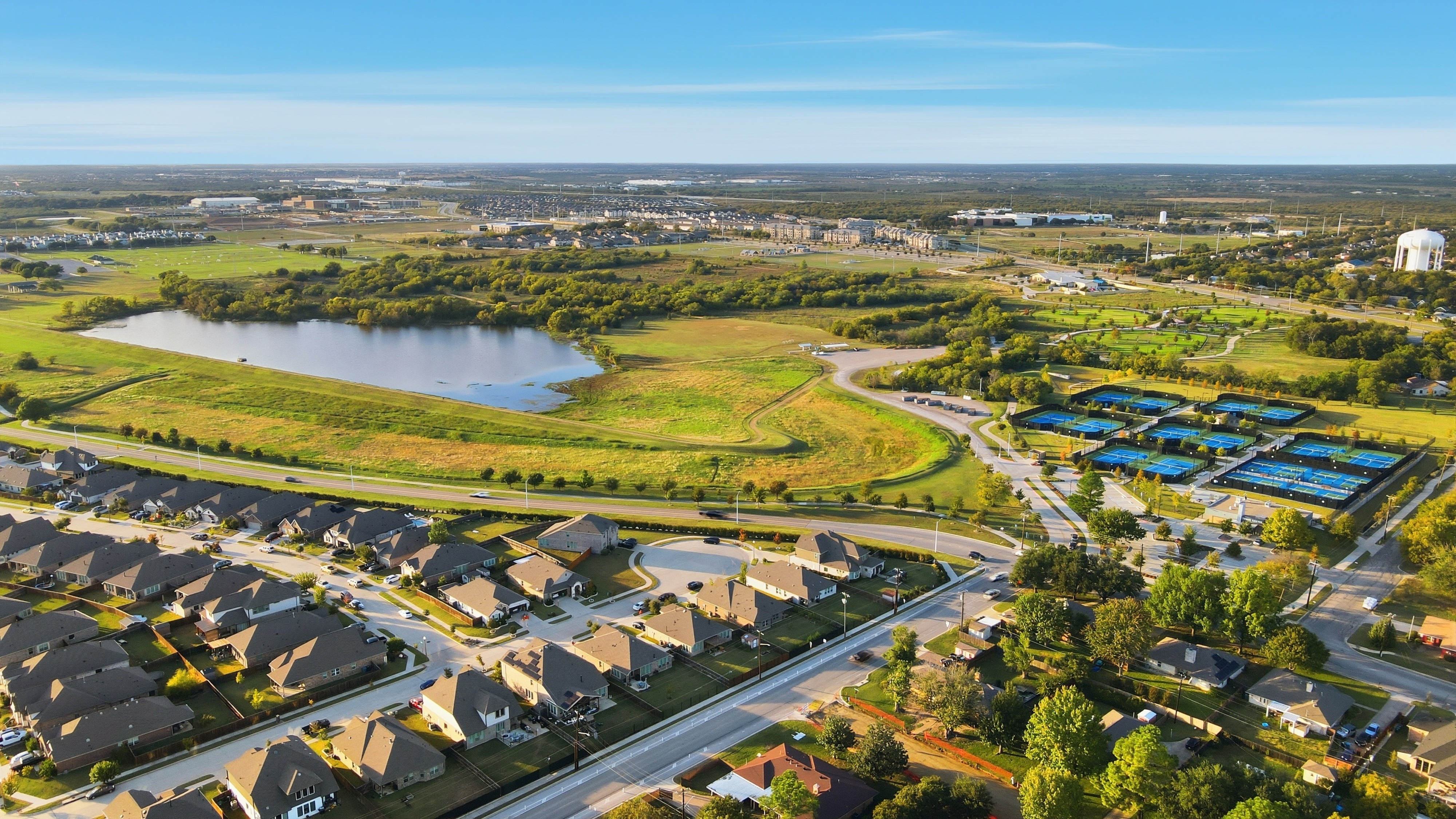 Aerial view — DFW neighborhood, lake and parks at golden hour